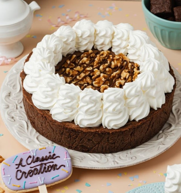 A decadent chocolate cake with a fudgy brownie crust, velvety whipped cream, crunchy walnuts, and rich chocolate drizzle. A must-try celebration cake!